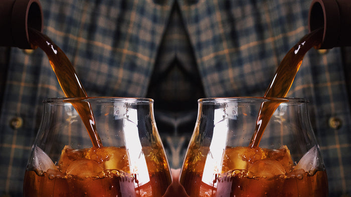 A mirrored image of cold brew being poured into an iced glass.