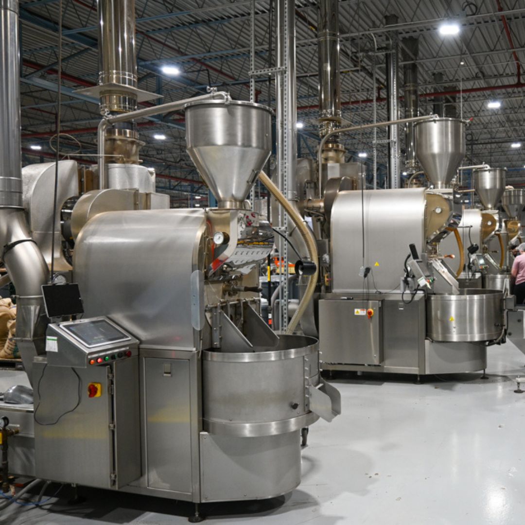 Photo of production floor at Fresh Roasted Coffee LLC, depicting 3 silver Loring Smart Roasters